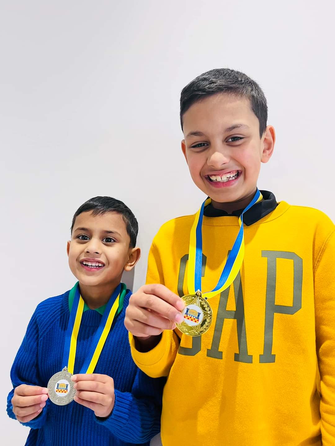 Riaan Shrivastava holding a chess club medal