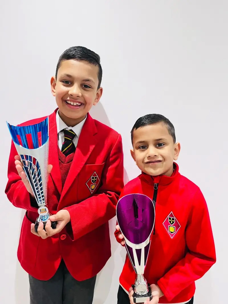 Two students holding trophies